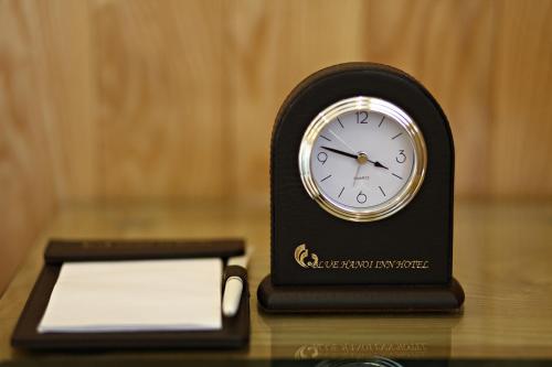 a black clock sitting on top of a table at Blue Hanoi Hotel in Hanoi