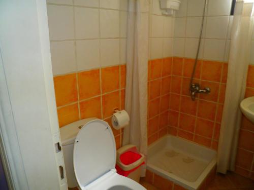 a bathroom with a toilet and a shower and a sink at Stone Chalets in Fārayyā
