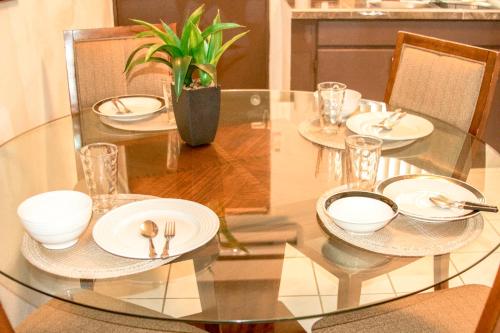 a glass table with plates and silverware on it at 2 BEDROOM / 1 BATH ONLY 5 MINUTES AWAY FROM BANK OF HAWAII in Sinajana