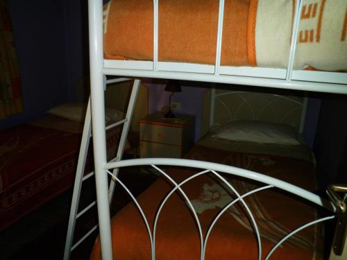 a bunk bed in a small room with a ladder at Stone Chalets in Fārayyā