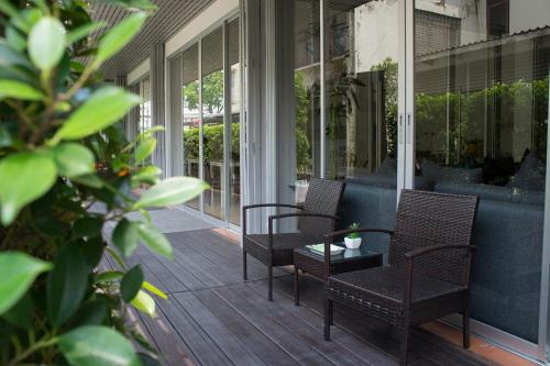 un porche con 2 sillas y una mesa en Ratchadamnoen Residence, en Bangkok
