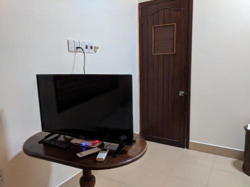 une télévision posée sur une table devant une porte dans l'établissement Khách sạn Đồng Dao, à Hue