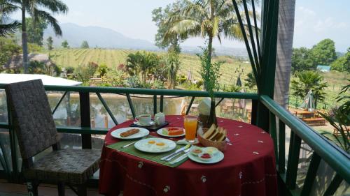 a table with food and drinks on a balcony at Aythaya Monte diVino Lodge in Taunggyi