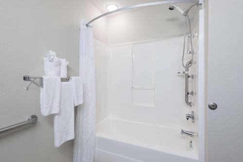 a bathroom with a shower with white towels at Microtel Inn & Suites - Greenville in Greenville
