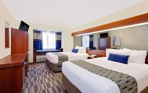 Кровать или кровати в номере Microtel Inn & Suites by Wyndham Middletown