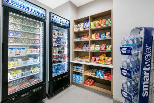 a grocery store aisle with two refrigerators and drinks at Microtel Inn & Suites by Wyndham Lubbock in Lubbock