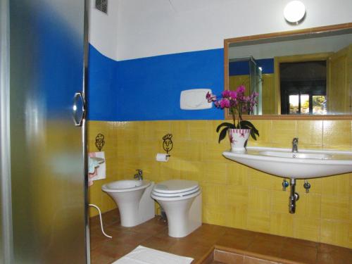 a bathroom with a sink and a toilet and a mirror at Locanda Degli Etruschi in Montalto di Castro