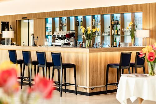 a bar with blue chairs in a restaurant at Hotel Thalhof am See in Caldaro