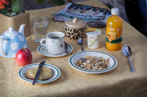a table with plates of breakfast food and a cup of coffee at Quilters Studio in Gawler