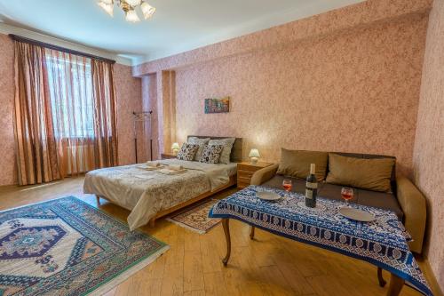 a living room with a bed and a couch at Alpha Tbilisi in Tbilisi City