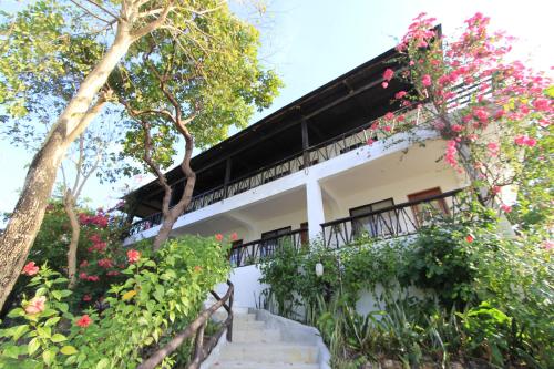 a house with flowers on the side of it at Discovery Island Resort in Coron