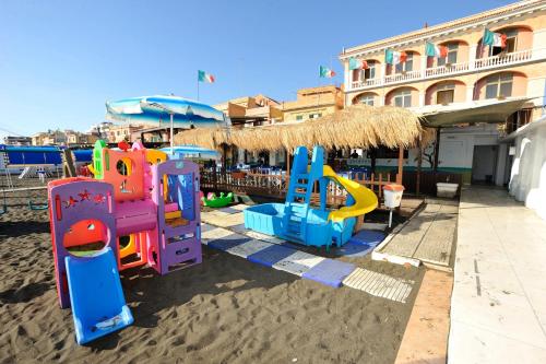 a playground in the sand in front of a building at Hotel Miramare in Ladispoli
