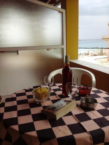 a table with a bottle of wine on a checkered table cloth at MARGARITAS' ROOMS in Agios Gordios