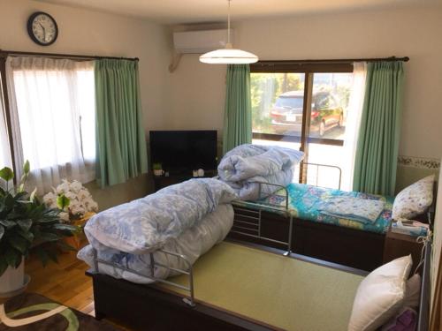 a bedroom with two bunk beds and a tv at Guesthouse Suisennosato in Konan