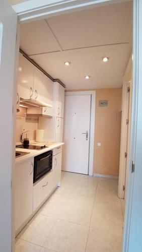 a kitchen with white cabinets and a stove top oven at Mirador in Alicante