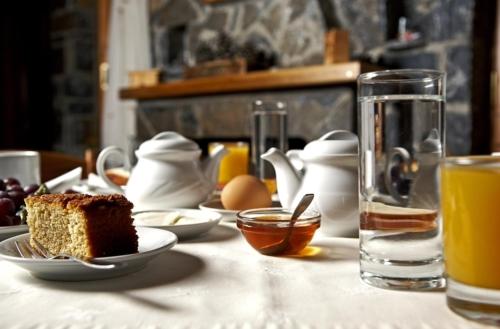 a table with a piece of cake and a glass of orange juice at Hotel Semeli in Goura