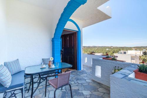 a patio with a blue table and chairs on a balcony at Schoner Blick in Sitia