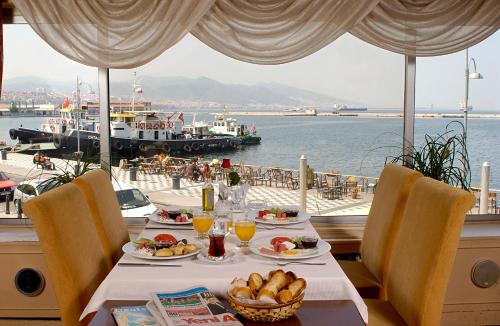 a table with food and a view of the water at Kilim Hotel Izmir in Izmir