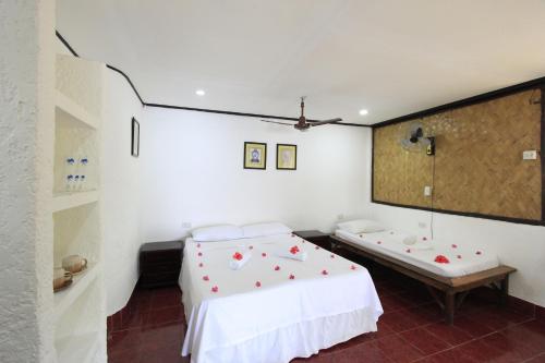 a bedroom with a bed and a bench in it at Discovery Island Resort in Coron