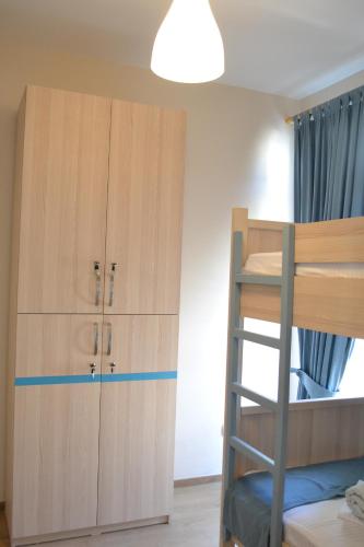 a bunk bed with a ladder next to a closet at Open Doors Bed & Breakfast in Shkodër