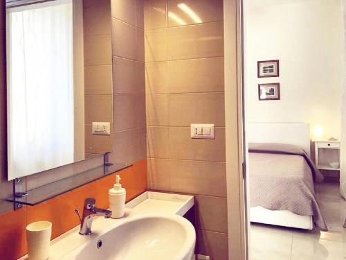 ein Bad mit einem Waschbecken, einem Spiegel und einem Bett in der Unterkunft B&B La Suite Gallipoli in Gallipoli