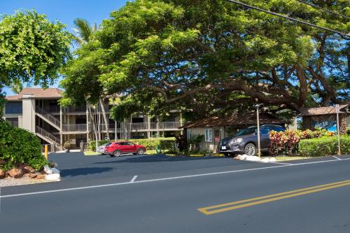 a street with cars parked in front of a building at Noelani 304 in Kahana
