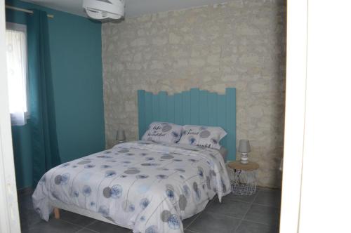 une chambre avec un lit avec un mur bleu dans l'établissement Prés du zoo de beauval, Gîtes agréable 