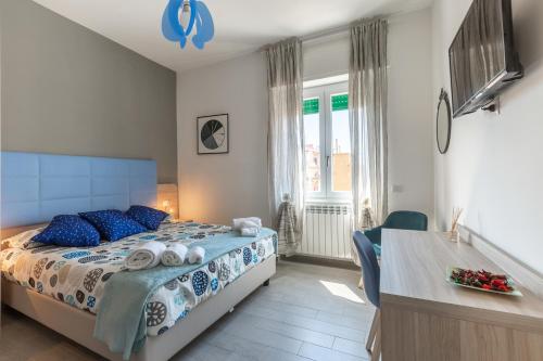 - une chambre avec un lit doté d'oreillers bleus et d'un bureau dans l'établissement La Casa di Anto, à Rome