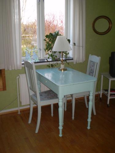 una mesa blanca con dos sillas y una lámpara. en Merkurvej Bed & Breakfast, en Aalborg