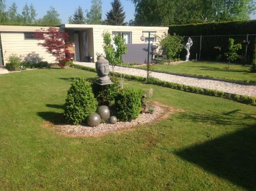 a garden with a statue in the middle of a yard at B&B Marianne in Binche