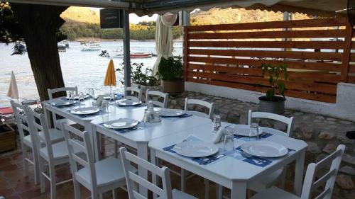 a white table with white chairs and plates on it at Golden Moon in Tolo