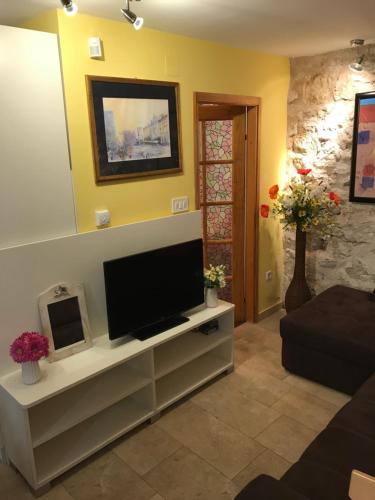 ein Wohnzimmer mit einem TV in einem weißen Unterhaltungszentrum in der Unterkunft Apartman Toni in Tribunj