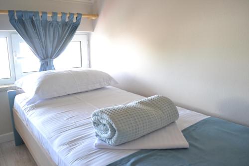 a small bedroom with a white bed with a window at Open Doors Bed & Breakfast in Shkodër
