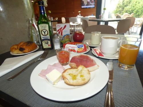 a table with a white plate of food and drinks at Eco Via Lusitana in Madrid