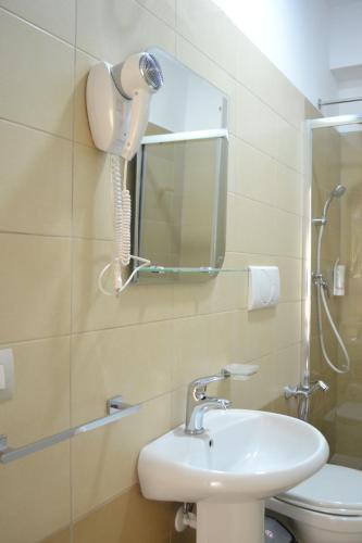 a bathroom with a sink and a mirror and a toilet at Open Doors Bed & Breakfast in Shkodër