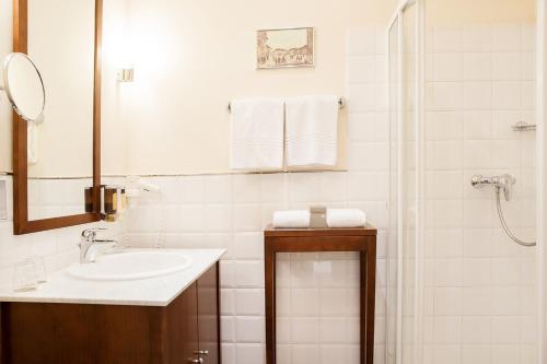 a white bathroom with a sink and a shower at Hotel Sandwirth in Klagenfurt