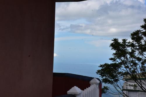 a view of a white fence and a tree at RIO Homestay in Haputale