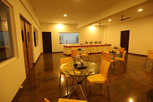 a dining room with tables and chairs in a room at Hotel Jump In & Out in Coimbatore