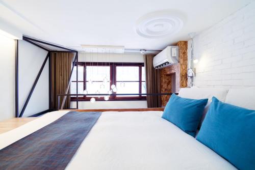 a bedroom with a large bed with blue pillows at With Inn Hostel in Kaohsiung