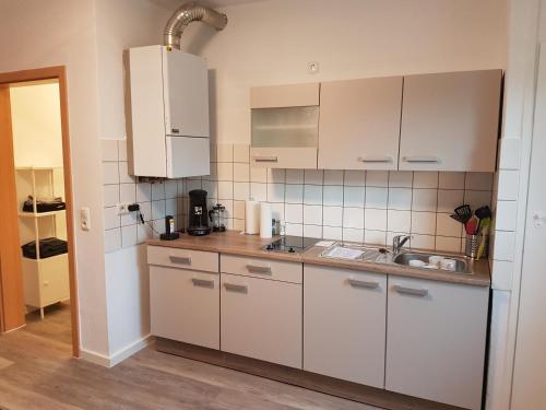 una cocina con armarios blancos y fregadero en Kleine, ruhige Wohnung in Gelsenkirchen en Gelsenkirchen