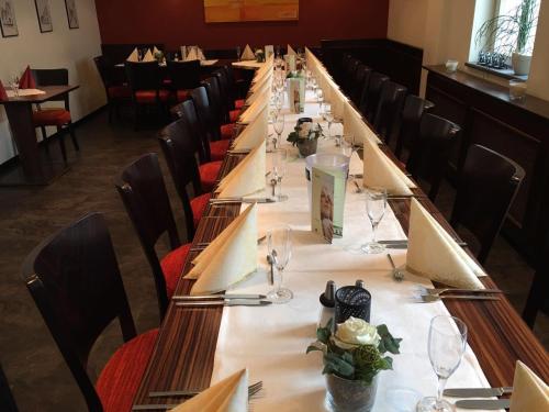 a long table in a restaurant with empty chairs at Gasthof Im Kohl in Neuenrade