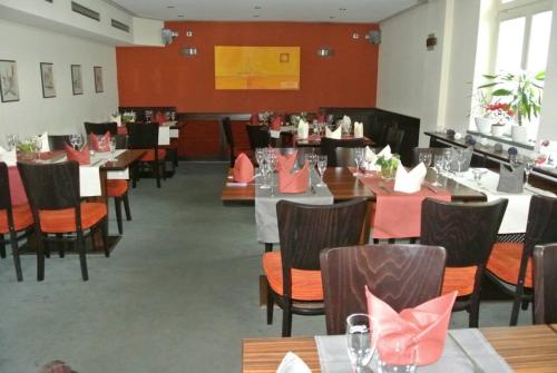 un comedor con mesas y sillas con servilletas rosas en Gasthof Im Kohl en Neuenrade
