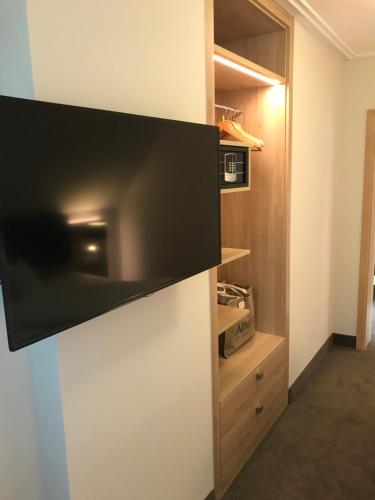a tv hanging on a wall in a room at Forellenhof Rössle Hotel & Restaurant in Honau