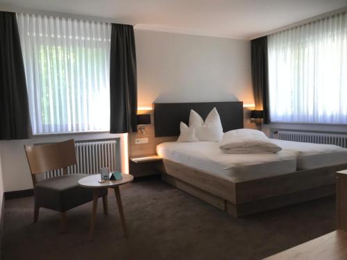 a hotel room with a bed and a chair and a table at Forellenhof Rössle Hotel & Restaurant in Honau