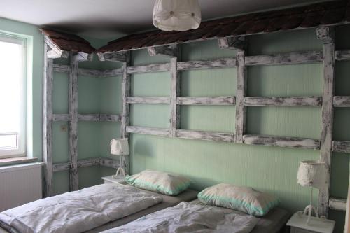 een slaapkamer met groene muren en een bed met kussens bij Spreewald Ferienwohnung Lübben in Lübben