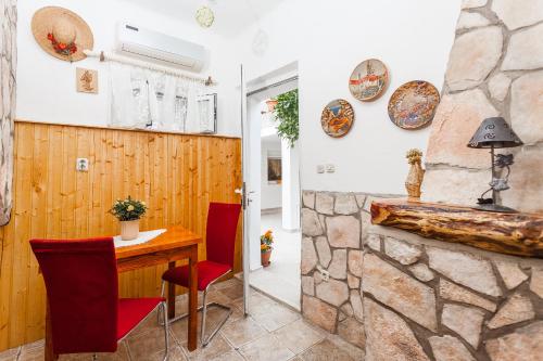 a room with a table and chairs and a stone wall at Guest House Mara in Vela Luka