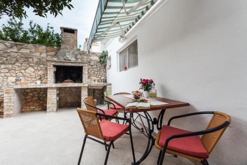 a patio with a table and chairs and a fireplace at Guest House Mara in Vela Luka