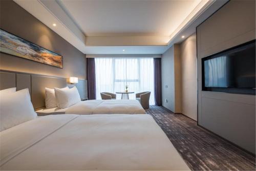 Een bed of bedden in een kamer bij Mercure Yantai Golden Beach