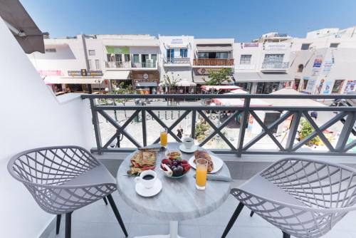 stół z jedzeniem i napojami na balkonie w obiekcie Santorini Main Square w Firze