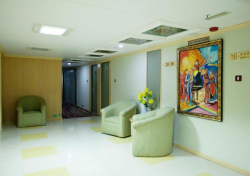 a waiting room with two chairs and a painting on the wall at Ramoji Film City- Tara Comfort Hotel in Pedda Ambarpet